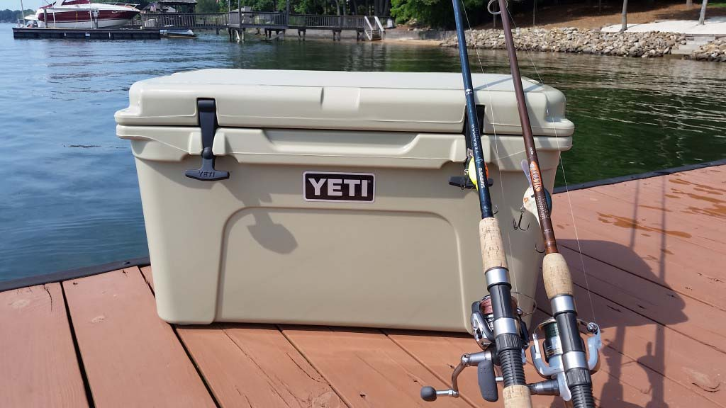 A durable yeti cooler gray sitting on a boat deck representing modern outdoor gear.