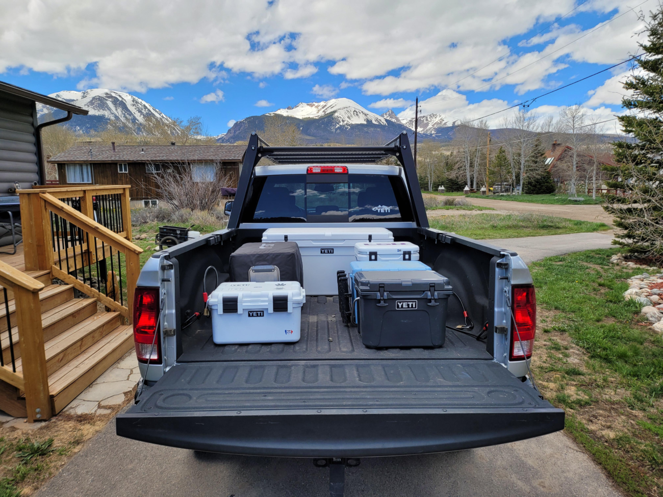 Alt text: {A charcoal yeti cooler grey hard cooler sitting in a truck bed for camping