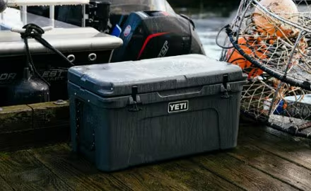 Durable gray yeti cooler sitting on a truck tailgate in the mountains