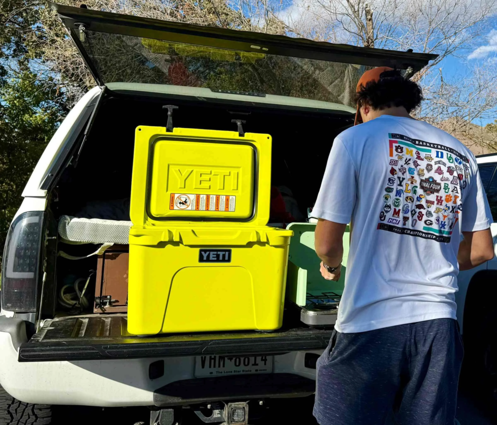 Loading a large capacity cooler into a truck for a camping trip