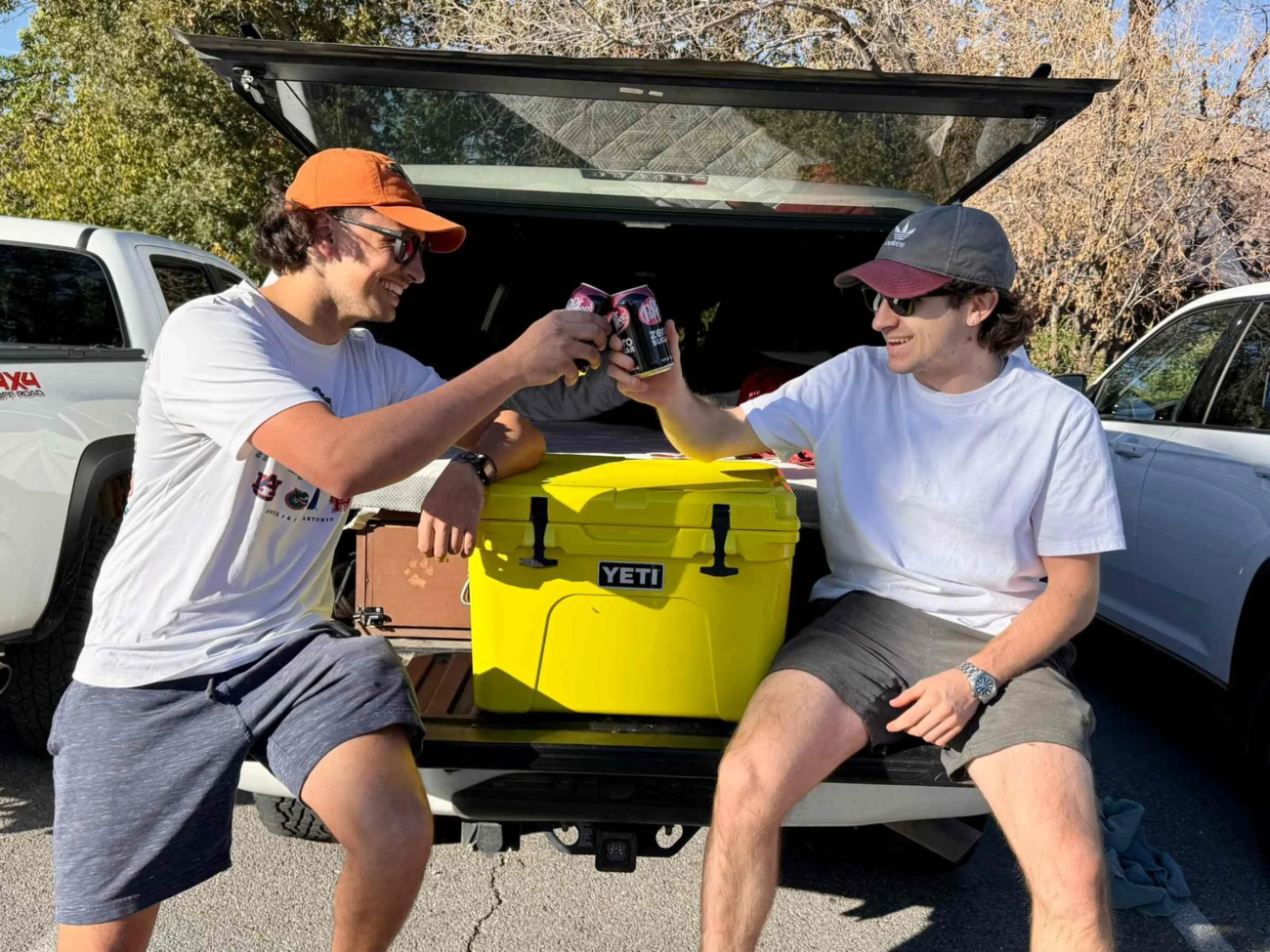 A group of outdoor enthusiasts using a YETI Tundra cooler during a camping trip with the yeti cooler phone number in mind for support