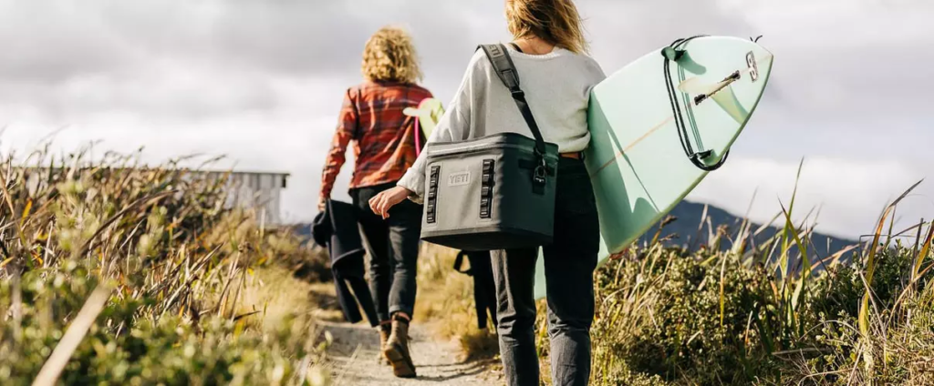 Lightweight yeti gear soft cooler bag being carried by a person on a beach