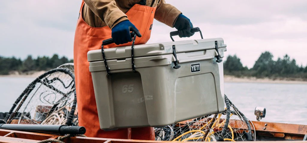 A person choosing to buy YETI coolers for a camping trip near a lake